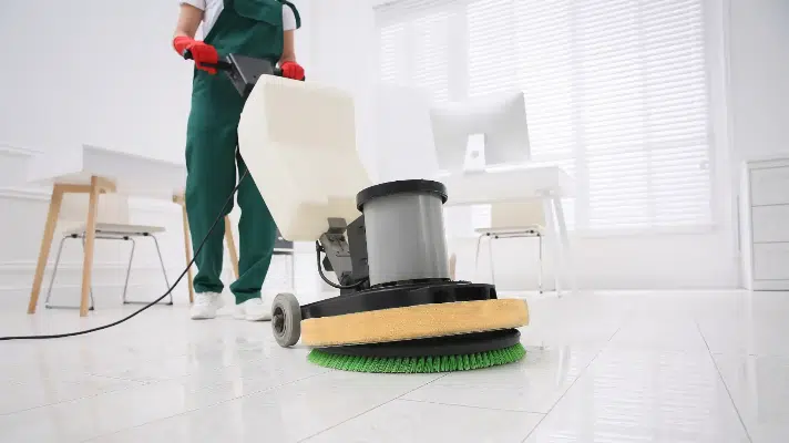 Professional cleaner using commercial cleaning equipment to polish and clean tiled floors