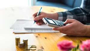 Man managing commercial cleaning budget with a calculator