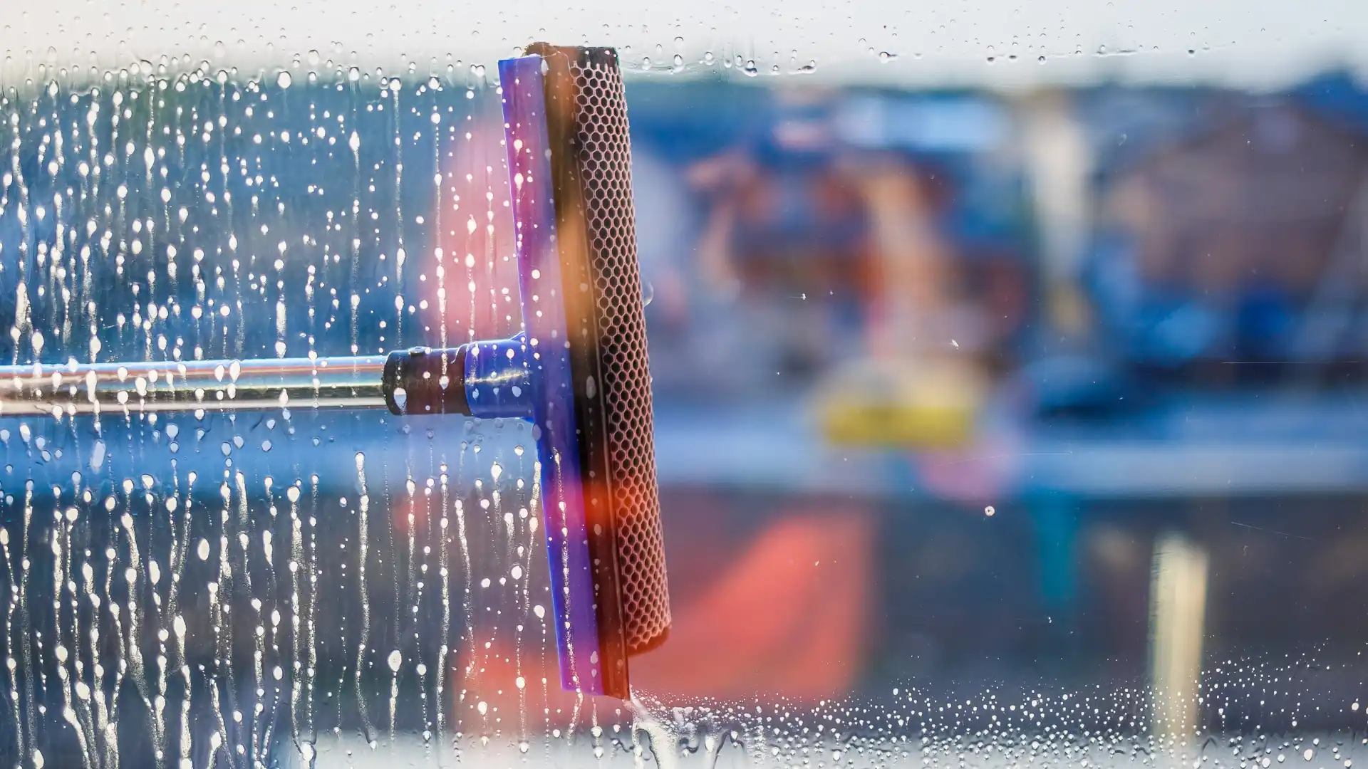 Office window cleaning – a squeegee removes water from an office window