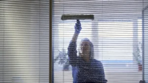 A professional window cleaner, cleaning an office window